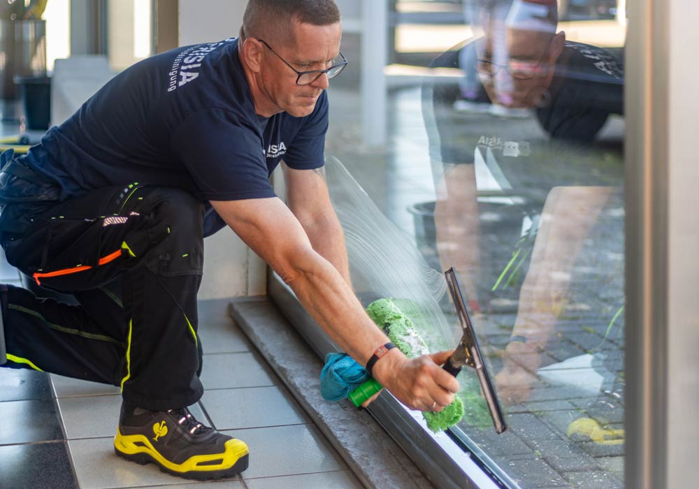 Mitarbeitende führen Glasreinigung durch